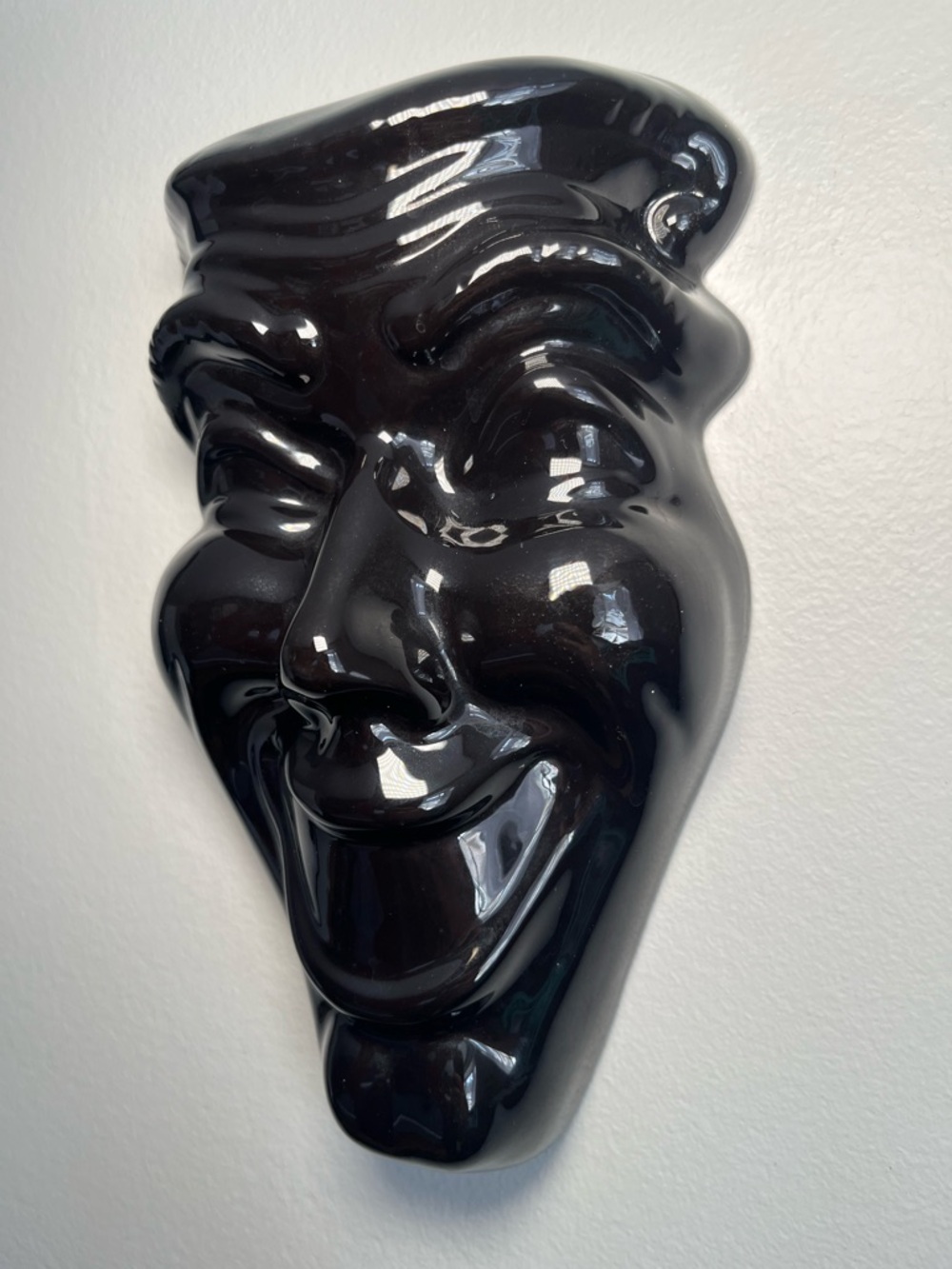 Vintage black ceramic "Smile Now Cry Later" decorative mask.
